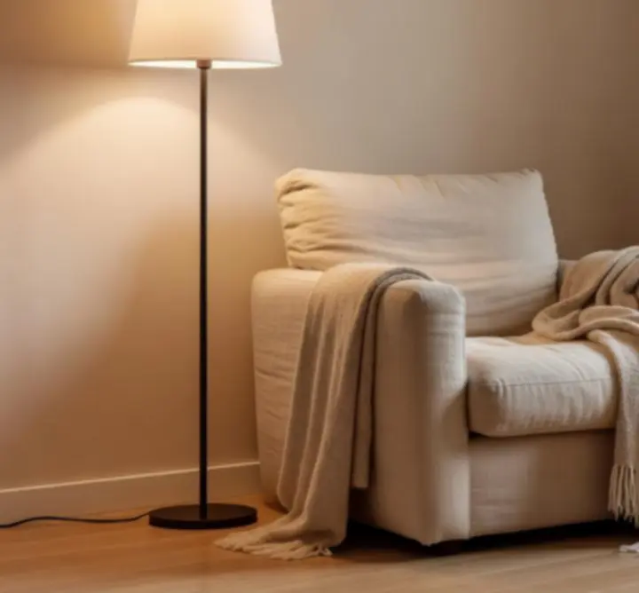 Lampa podłogowa ustawiona przy fotelu do czytania
